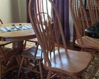 Oak Amish made Windsor back bar stools. In background round oak pedestal table with 2 leaves making it an oval oak table.  Amish made
