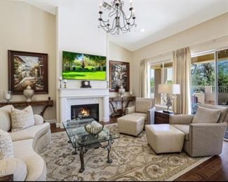 Robb and Stucky cream skirted sofa $750;underfoot large area rug $800; ladlows genuine leather ottomans $300 each, Robb and Stucky glass and iron coffee table $400