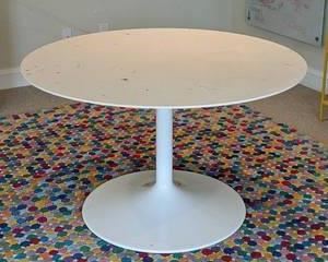 Round Tulip Dining Table. This table was used as a children's craft table and has several paint stains on the top and unknown if removable with cleaning. Perfect table for that budding artist who can use the paint look on the table as inspiration! Measures 48” in diameter and 28” high.