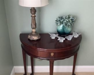 Half moon end table with lamp.  Measure 36” l x 30” h x 16” d. This table is a gateleg table and becomes a round top