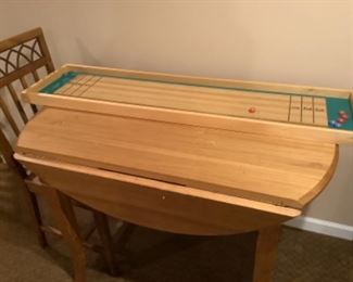Drop leaf table with two chairs and a table top size shuffleboard