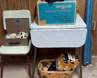 Argus Slide Projector, Slide Holders, Slides, Pull Down Screen And Vintage Table And Chair