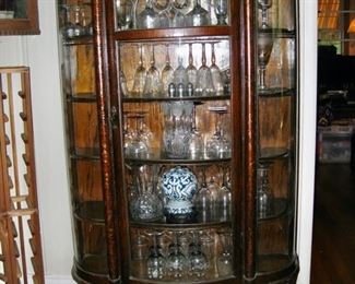 $395 Antique tiger oak finish serpentine, claw foot curio with leaded glass panel 38" w x 15" deep x 62" tall