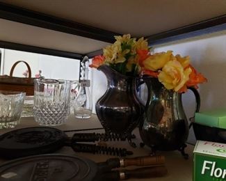 Elegant silver water pitchers adorned with flowers.