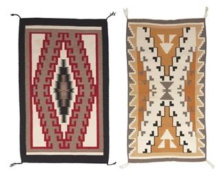 2034
Two Navajo Regional Rugs
Mid-20th Century; Diné
Two regional rugs, one woven in tan, ochre, cream, grey and black wool with an X-motif to center with a stepped border to each side (45" H x 25" W) and one woven in cream, brown/grey, red, and black wool with a hooked central diamond and black border (44.5" H x 27.75" W), 2 pieces
Estimate: $400 - $600