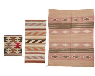 2038
A Group Of Navajo Textiles
Second Half 20th Century; Diné
Comprising a small Navajo banded revival rug woven in brown, pink, peach, cream, and grey wool (48.5" H x 38" W) and two small Gallup throw mats, one a banded runner woven in cream, brown, orange, red, blue, and tan wool (37" H x 19" W) the second a small mat woven in cream, purple, red, brown, and black wool with multiple hourglass motifs (18" H x 16.5" W), 3 pieces
Estimate: $200 - $300
