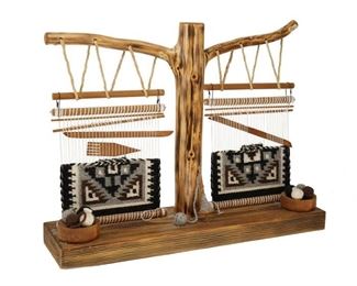 2040
A Double Loom With Navajo Two Grey Hills Weaving Samples
Fourth-Quarter 20th Century; Diné
Comprised of a double loom formed from a natural wood branch, with two Two Grey Hills wool weaving samples attached as well as various miniature tools and implements, such as a spindle with wool, weaver's comb and batten, and two wooden pots with balls of wool
15.75" H x 20.375" W x 5.375" D
Estimate: $200 - $400