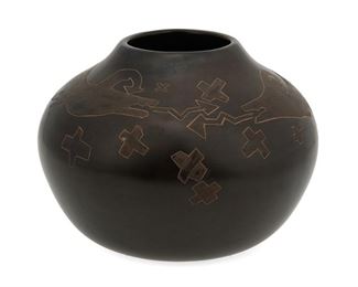 2066
Kaa Folwell (B. 1991, Santa Clara)
An etched pottery bowl
Marked to underside: [Artist's cipher] / 15
A brownware pottery bowl with black fire clouding and incised double Avanyu and cross motifs highlighted with applied shimmery or micaceous slip glaze
5.25" H x 7.25" Dia.
Estimate: $600 - $900