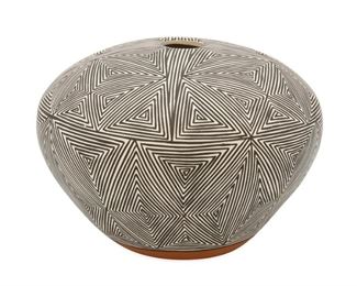 2070
Marie Zieu Chino (1907-1982, Acoma Pueblo)
An Acoma Pueblo pottery seed pot
Signed to underside: Acoma / M. Chino
The black-on-white pottery vessel with black fineline starburst pattern on white slip glaze with red foot
4" H x 5.75" Dia.
Estimate: $200 - $300