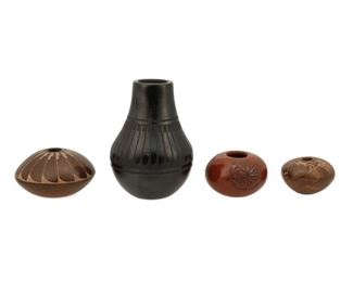 2081
A Group Of Puebloan Pottery Vessels
Four works:

A Crucita "Blue Corn" Calabaza San Ildefonso Pueblo blackware vessel
(1921-1999, San Ildefonso Pueblo)
Signed to underside: Blue Corn / San Ildefonso Pueblo
The blackware pottery jar with burnished slip glaze and matte slip painted feather pattern to the shoulder
6" H x 4" Dia.

A Lois and Derek Gutierrez de la Cruz Santa Clara Pueblo vessel
(Lois: b. 1948, Santa Clara Pueblo)
Signed to underside: Lois Derek
The miniature black-on-red pottery vessel with burnished red slip glaze and matte black slip painted geometric medallions
2.125" H x 3.25" Dia.

A Pearl Talachy Nambe Pueblo sgraffito vessel
(b. 1952, Nambe Pueblo)
Signed to underside: Pearl Talachy / Nambe Pblo [sic] / NM
The miniature sgraffito pottery vessel with burnished, gradient slip glaze going brown to red with shallow carved feather pattern
2.5" H x 4" Dia.

A Dusty Naranjo Santa Clara Pueblo sgraffito seed pot
(b. 1968, Santa Clara Pueblo)
Signed and dated to undersid