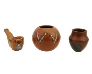 2086
Three Navajo Pottery Items
Three works:

A Lorraine Williams-Yazzie jar
(b. 1955, Diné)
Signed to underside: [LW cipher]
The globular pot with red slip glaze and incised, polychrome stepped chevrons
3" H x 3.5" Dia.

An Alice Cling miniature jar
(b. 1946, Diné)
Signed to underside: Alice Cling
With red slip glaze with black fire-clouding
2.625" H x 2.5" Dia.

A Silas and Bertha Claw pipe
(1913-2002 and b. 1926, Diné)
Signed to underside: S. B. Claw
With red slip glaze with black fire-clouding and a high relief polychrome deer
2" H x 1.875" W x 4.125" D

3 pieces
Estimate: $75 - $125