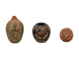 2091
Three Santa Clara Pueblo Miniature Sgraffito Pottery Vessels
Three works:

An Emily Tafoya seed pot
(b. 1959, Santa Clara Pueblo)
Signed to underside: Emily Tafoya [artist's cipher] / M / SCP
With burnished green slip glaze and shallow carved pueblo buildings and fluteplayers
2.75" H x 1.75" Dia.

A Mike and Jennifer Moquino jar
(Jennifer: b.1977, Santa Clara Pueblo)
Signed to underside: Mike and Jennifer [artist's cipher]
With burnished black slip glaze and shallow carved flowers and butterflies
1.75" H x 1.75" Dia.

A Ray Tafoya seed pot
(1956 -I 994, Santa Clara Pueblo)
Signed to underside: [artist's cipher] / SCP
With burnished red slip glaze and shallow carved Mimbres-style rabbit
1.25" H x 1.25" Dia.

3 pieces
Estimate: $100 - $200