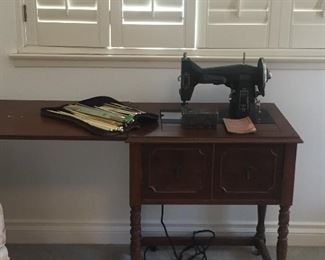 Antique sewing machine with cabinet. 