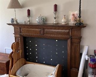 A bassinet in front of the fireplace.