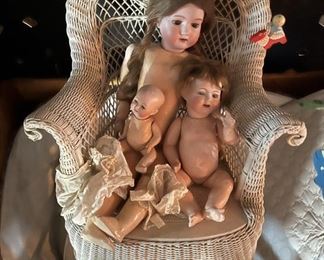 More dolls and a wicker chair.