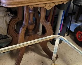 antique wooden table with carved detail, wrought iron base of glass top table