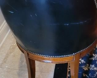 nail head design on vintage black leather chair with goose head arm design