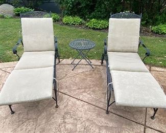 Pair of Adjustable Chaise Loungers and Small Accent Table. Chairs are on castors and have adjustable back heights.  In overall good condition with some very slight rust. Cushion have moisture stains and may need to be replaced. Fully reclined, each chair measures 6'x27w and the table measures 20" x 21" 