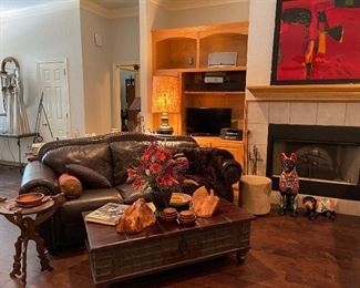 Wonderful leather sofa, rough cut trunk/coffee table, the wood pieces are wine bottle holders, great floral