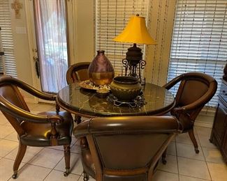 Beautiful top pedestal table with 4 arm chairs on casters. Metal accent pieces.