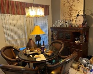 The dining area of the kitchen has a beautiful marble top pedestal table with four arm chairs, also a great hutch with a lighted cabinet, lots of bar ware