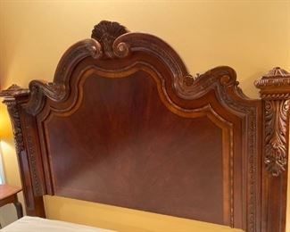 Beautiful Classic Queen Bed with Intricate Trim. It features four large posts with a layered base and swirled mahogany veneers