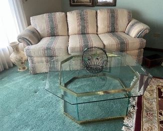 Upholstered couch and glass/brass coffee table