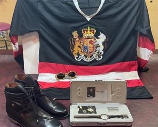  INV #323: Collection of Elton John memorabilia-Gianni Versace Shoes worn by Elton John 973/8                -Gianni Versace Sunglasses Mod. 527/B COL. P02            -Limited Edition Elton John Watch                                              -Elton John World Tour Jersey