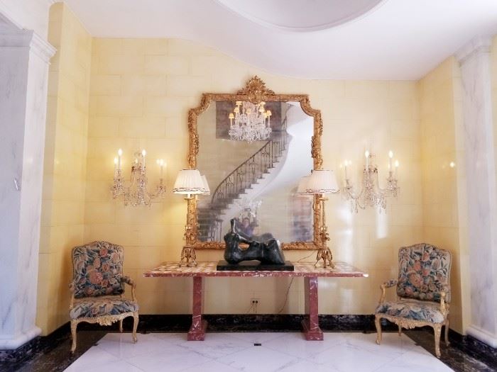Hines' grand entry hall by famed architect Robert Stern. Note: the Kensington Palace chandelier and 4 sconces are hanging off site and can be seen by appointment. The Regence period armchairs are sold.