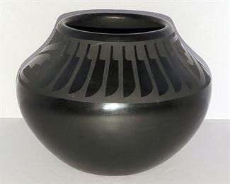 Black on black pot in fine condition with mirror finish signed Donicia Tafoya. 4" tall x 5" wide. Donicia Martinez (1912-1979) was the mother of noted potter Juan Tafoya and Elizabeth Lovato. She was married to Juan Tafoya, Sr. of Santa Clara Pueblo. She was the daughter of Teresa and Reyes Martinez.