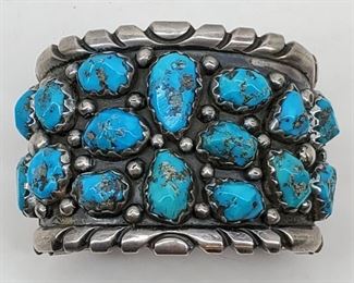 A heavy, stunning bracelet set with 16 turquoise nuggets, by Zuni artist Wayne Cheama. Wayne was the son of well known Zuni jewelry artist Angelita (Angie) Cheama. Circa 1960s/70s. Weighs 131 grams (4.60 ounces). 6" in circumference plus a 1" gap.