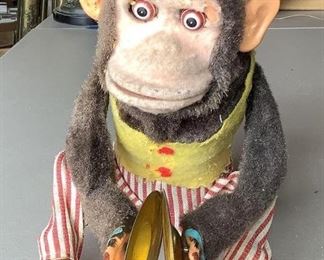Battery operated vintage fabric monkey toy with symbols and pendulum eyes. The fabric appears to be worn and faded, U,unknown working condition.u, H 10.5" x W 8.5".