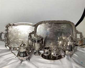 Wlm. Rogers silverplate serving pieces and more. Includes (1) Webster Wilcox serving tray, (1) Wlm. Rogers serving tray, (2) Wlm. Rogers tea pots with lids, (1) Wlm. Rogers sugar bowl with lid, (1) Wlm. Rogers creamer, (1) Ronson relish tray, and (1) additional tea pot. All items show wear indicative of age and use.