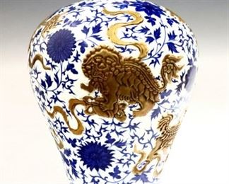 A Chinese Blue and White porcelain vase.  Hand-painted floral decoration with Gilded lions in relief.  Blue character mark.  Minor wear to decoration.  14" high. 
