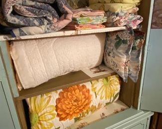 Cabinet in bedroom holding comforters and linens