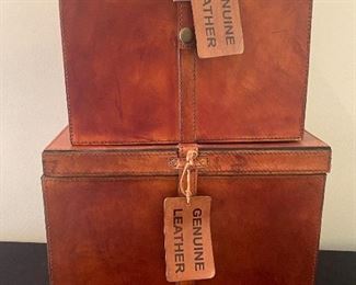 Two Genuine Leather Decorative Boxes measuring 12" x 12" x 10.5" and 10" x 10" x 8.5". Items in overall good condition with light wear. 