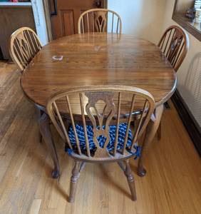Vintage Nichols and Stone Dining Set. There are scratches/damage on the tabletop and one chair leg is loose. The table as pictured measures 42” x 55” and 29” high. Includes two leaves and is pictured with one. 