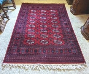Vibrant Red Wool Area Rug. There is some light wear and damage to the fringes that can be seen in the photos. Measures 55” x 81”.