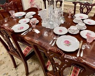 Mahogany Chippendale Dining Table w/6 Chairs- 45” L x 25” W, extra leaf allows seating for 8, table set w/Hutschenreuther “The Dundee” German China 8 place settings + add’l pieces, and pinks seed glass goblets. 