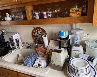  Coffee Makers; Filters; Osterizer 12-Speed Blender; OSTER Ice Shaver; Glassware; Round, Wooden Rosemaling Decorative Folk Art Hanging; Kitchen Towels; Electric Knife Sharpener