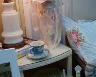 Milk glass and brass lamp, wicked side table, fabric garland, pillows