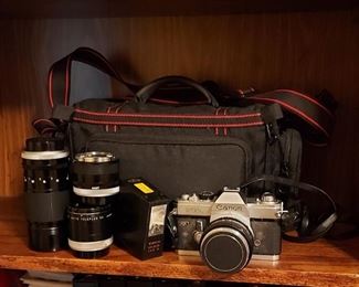 Vintage Canon FTb 35mm camera with three lenses and accessories