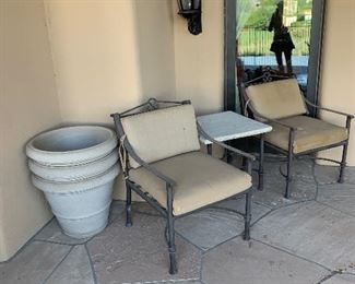 3 pots are stacked to the left of the chairs