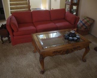 Glass top coffee table, sofa with brick red upholstery