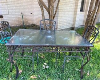Wrought iron glass-top table and three chairs