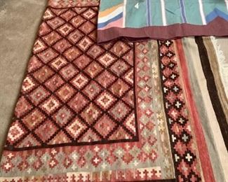 Two large Southwestern themed tassel floor rugs, (1) is green, pink, blue with a maroon border, H 113"x W 72", the other is coral, tans, dark brown diamond/geometric design, H 100"x W 64", no noticeable damage.