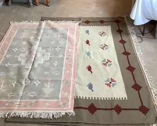 Two large Southwestern themed tassel floor rugs, (1) is pink and gray with floral design, appears to have an area of repair, H 75"x W 47", the other is large sized with tan, burgundy and green with bird design, H 130"x W 48". Both have some areas of staining.