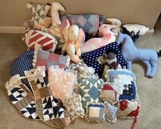 An assortment of quilted pillows that appear homemade, approximately (20). Includes squares, animal shapes and stockings. Some may have minor staining and tears