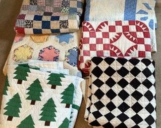 Includes (6) quilts, (5) appear to be homemade. One twin sized white with green trees, (1) black and white checkerboard pattern, (1) red and white checkered, (1) blue and white squares and pinwheels, (1) multi-colored patchwork with gray border and (1) white with multi-colored 6-point stars pattern. All may have tears, worn areas or stains, average size is approximately H 80" x W 65".