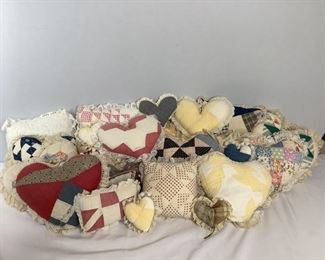 Approximately (25) quilted pillow in heart and square shapes. All are different sizes, shapes and colors. Some may have minor staining and tears.
